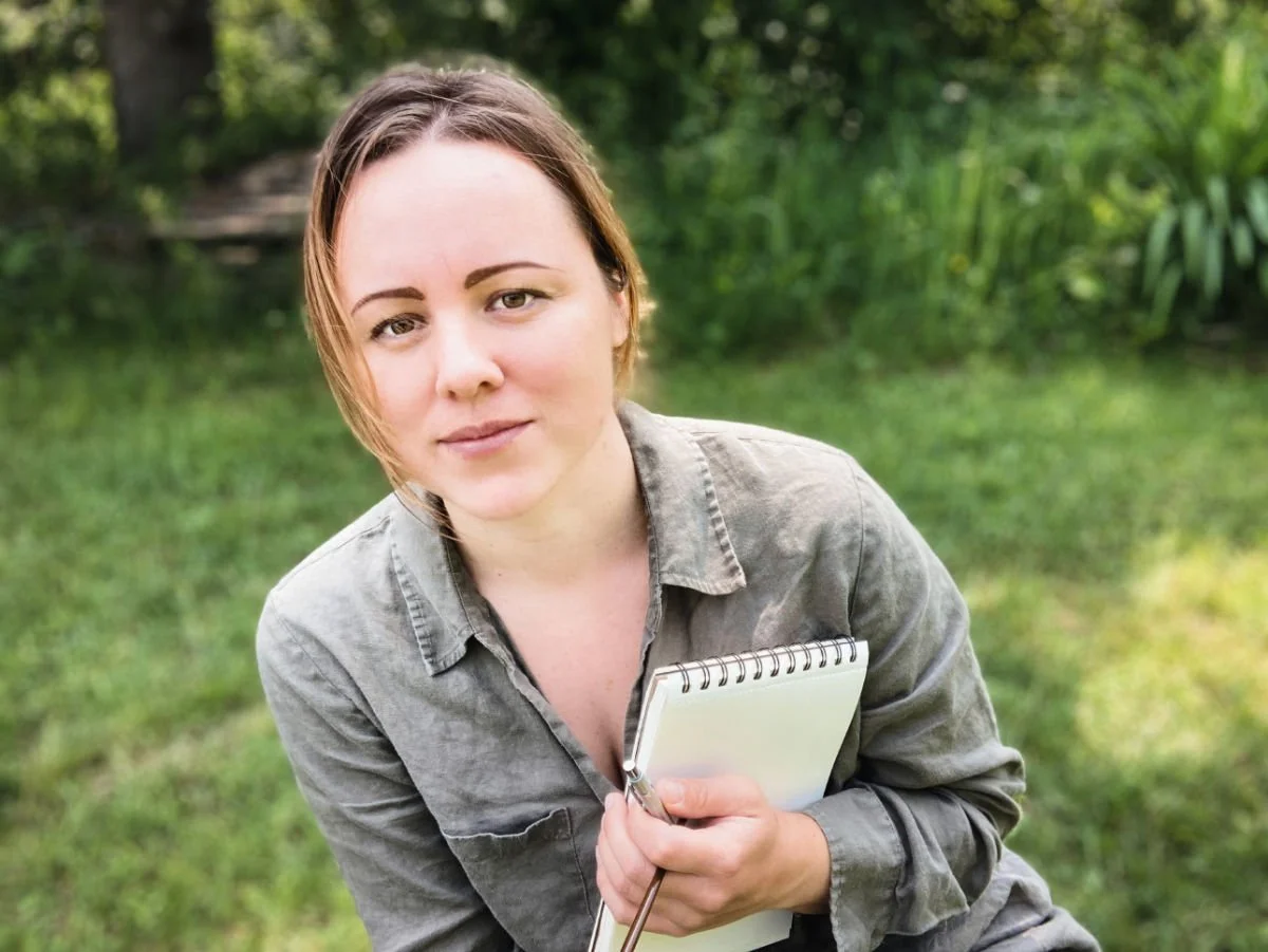 A photo of Rowan, Earth Artist holding a sketchbook