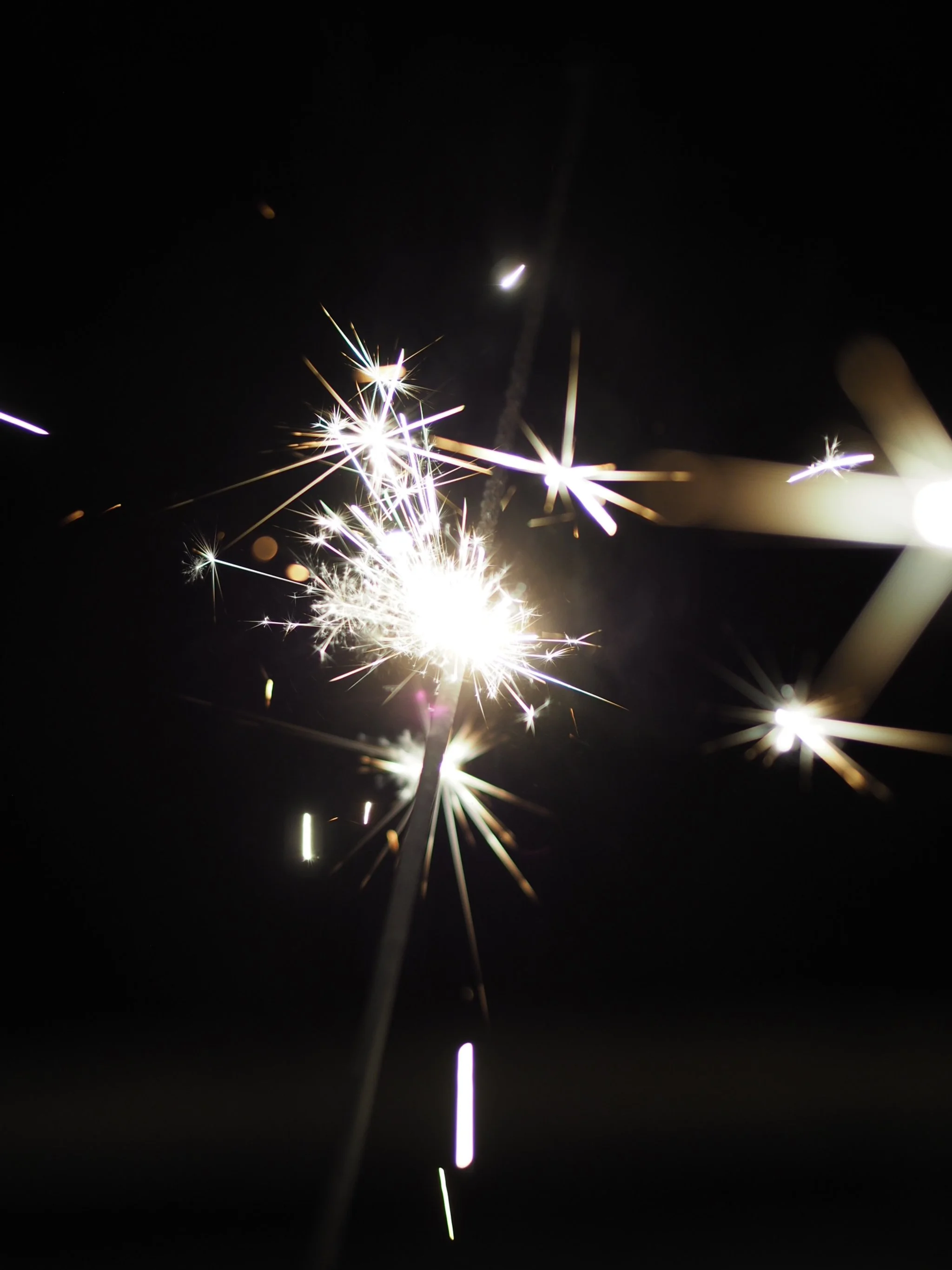 Kipinöivä tähtisädetikku pimeässä taustassa.