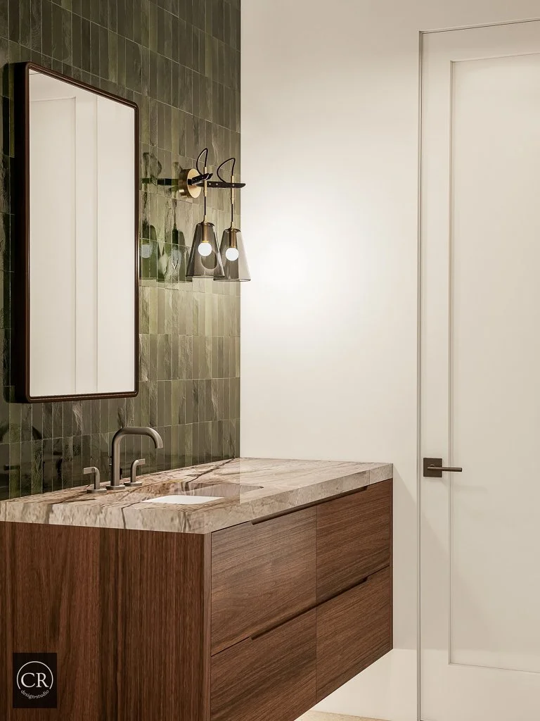 3D guest bathroom rendering with deep green zellige tile accent wall, walnut floating vanity, and brass sconce lighting
