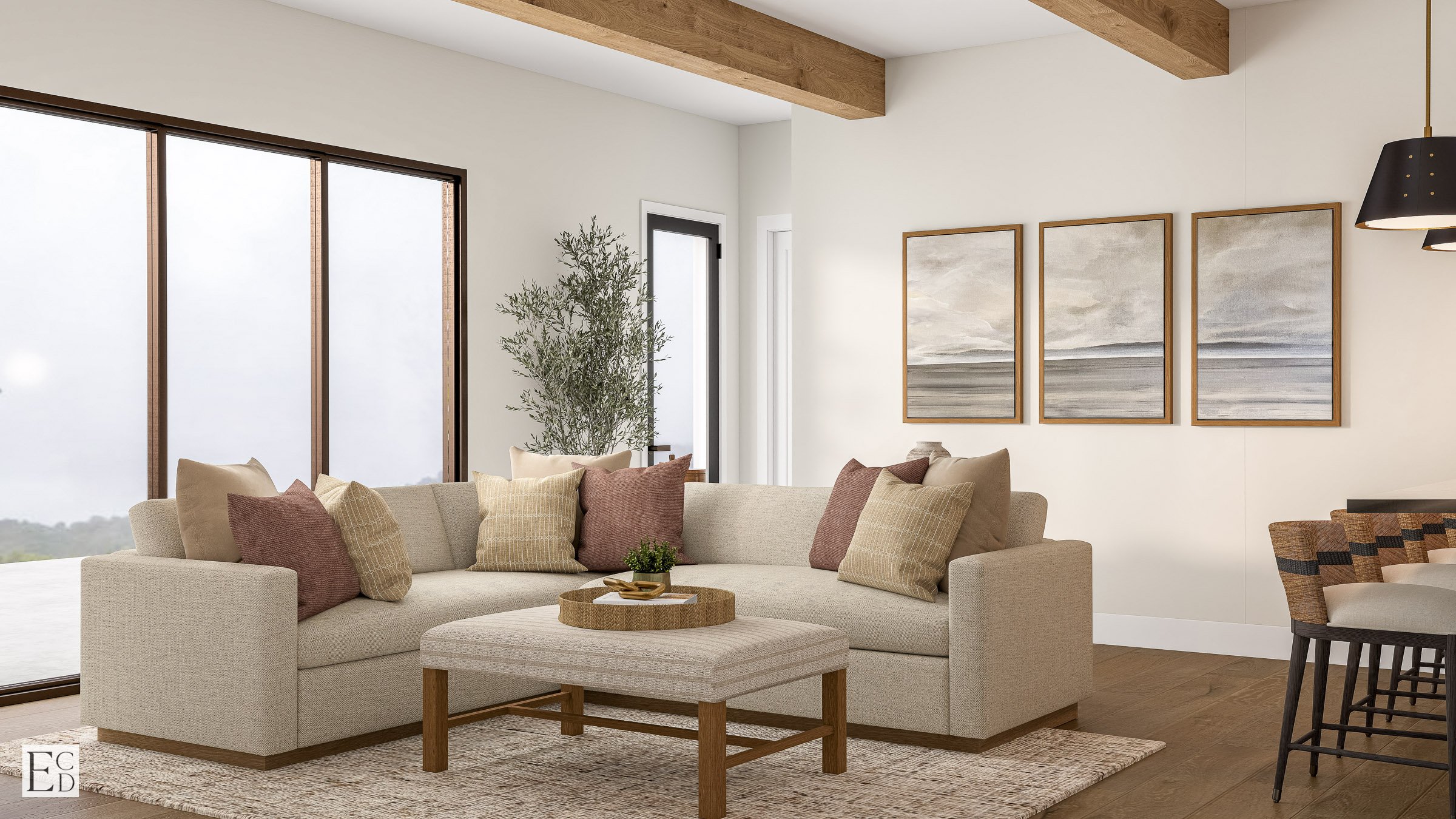 A deep sectional faces the windows, a trio of landscape prints on the long wall and bar seating just in frame.