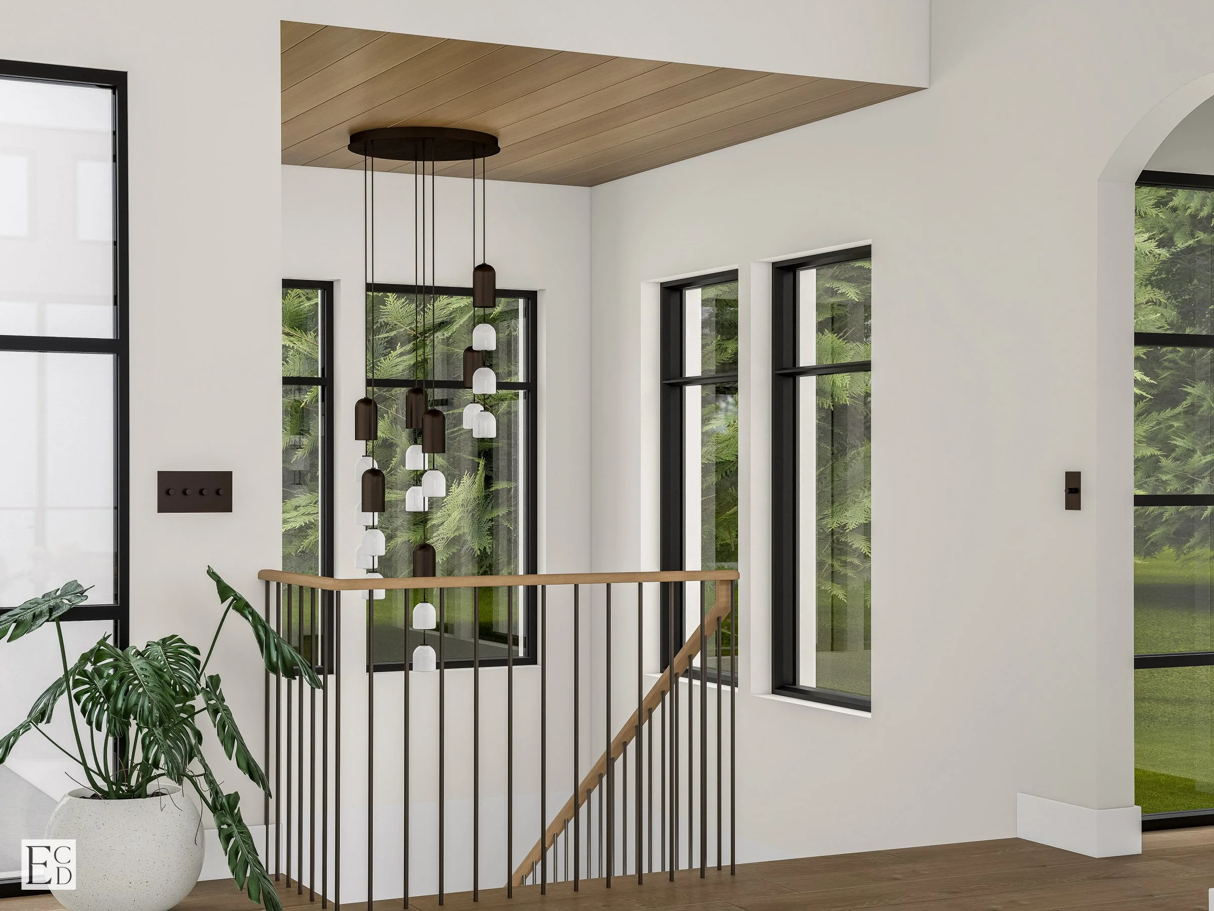 A cascading bell-pendant fixture drops through the stairwell against a run of black-framed windows and the trees beyond.