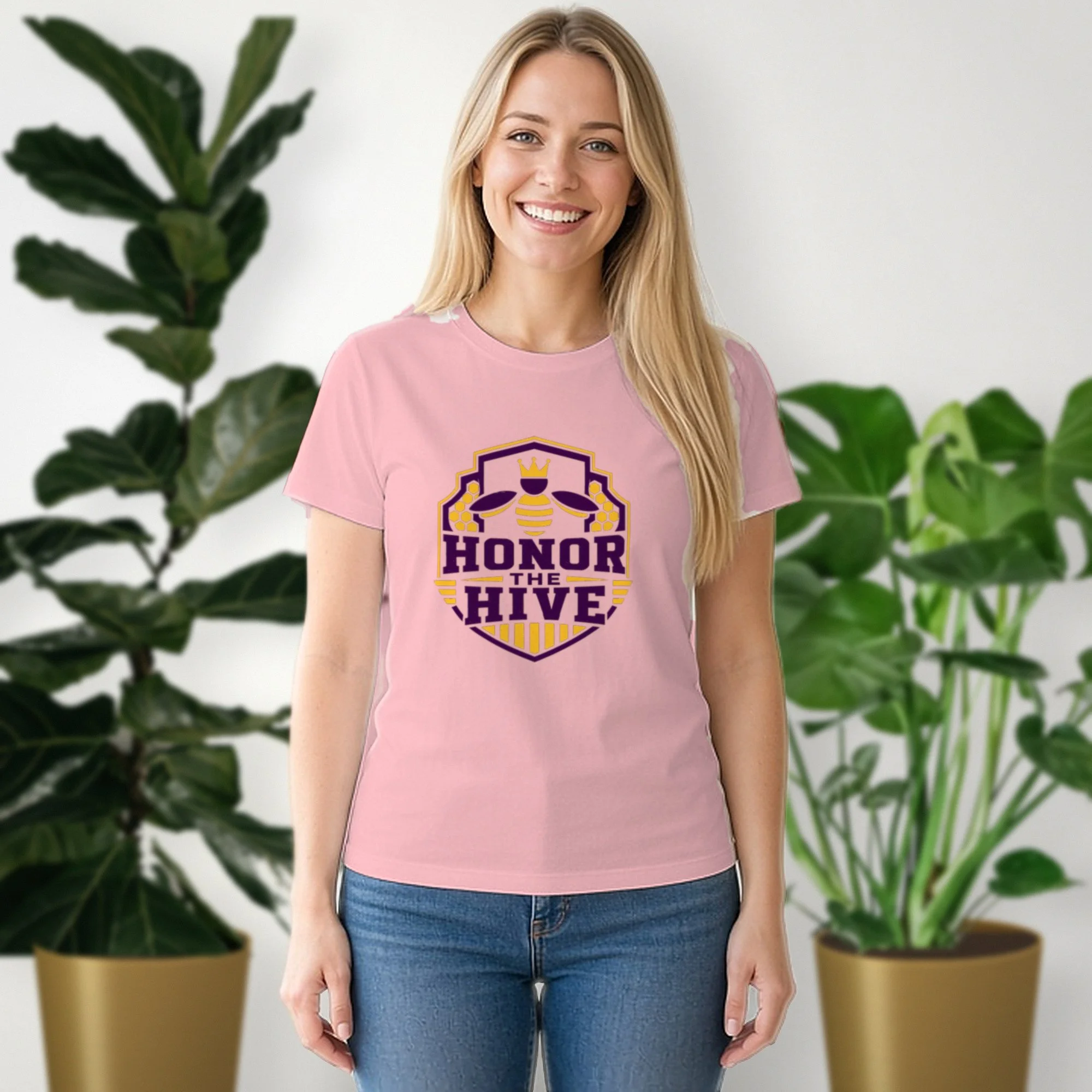 Honor the Hive tee in pink, worn by a model in front of potted plants
