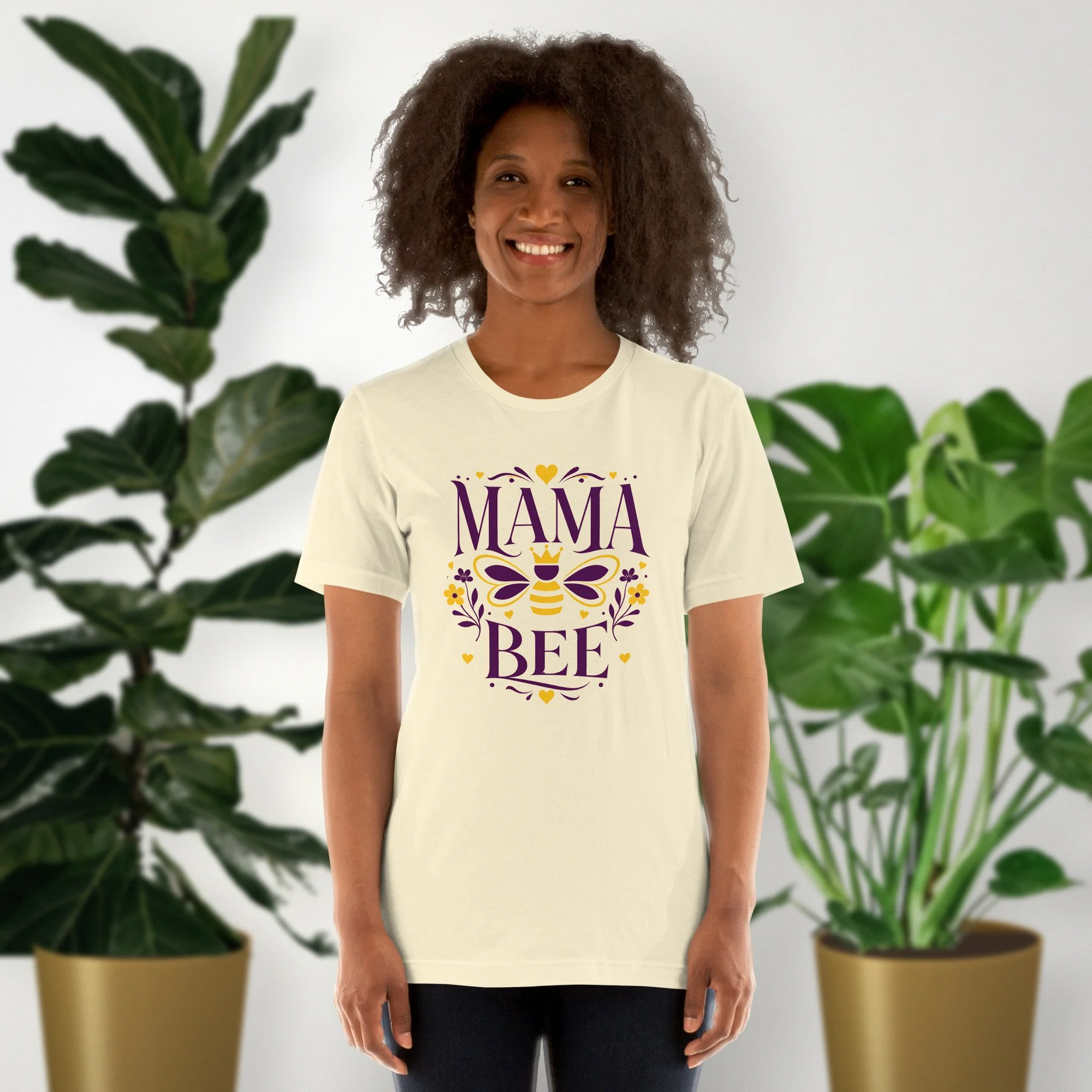 Mama Bee tee in natural, worn by a model in front of potted plants