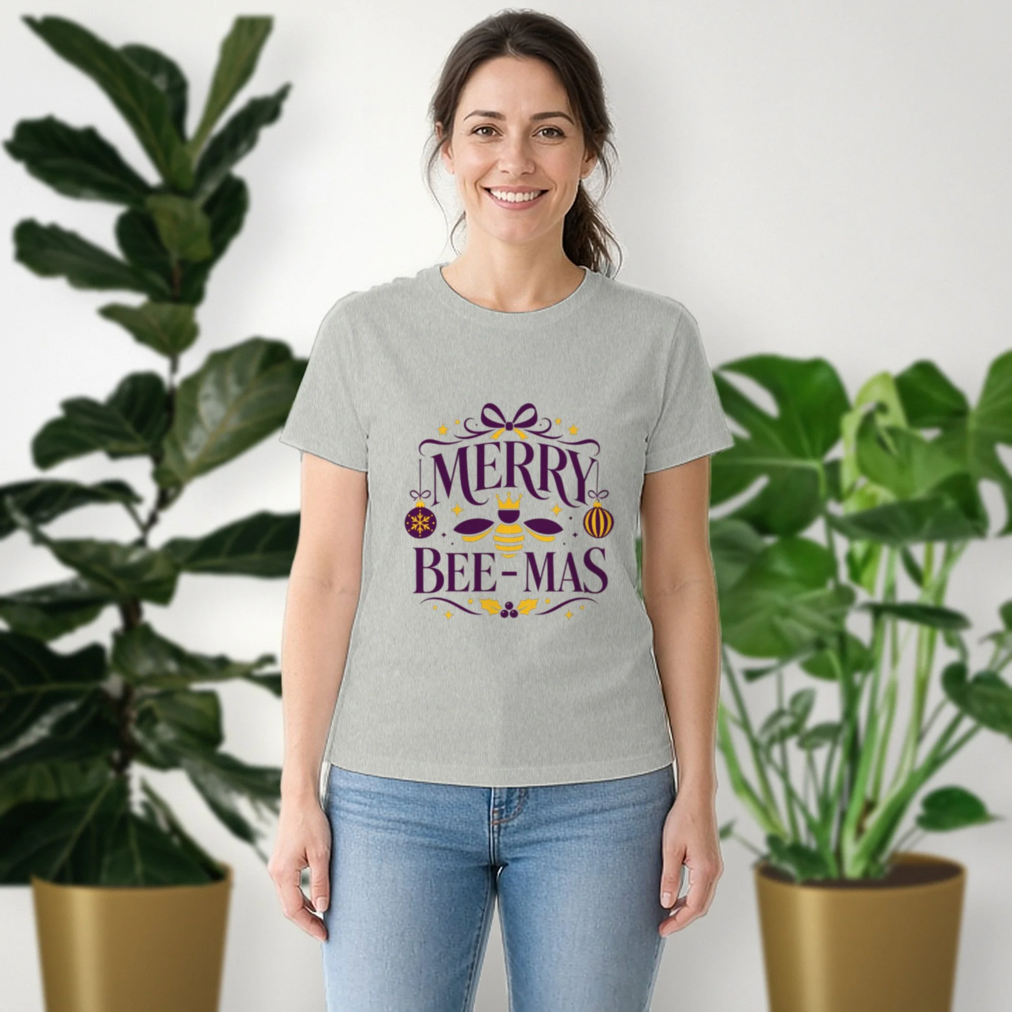 Merry Bee-mas tee in athletic heather, worn by a model in front of potted plants