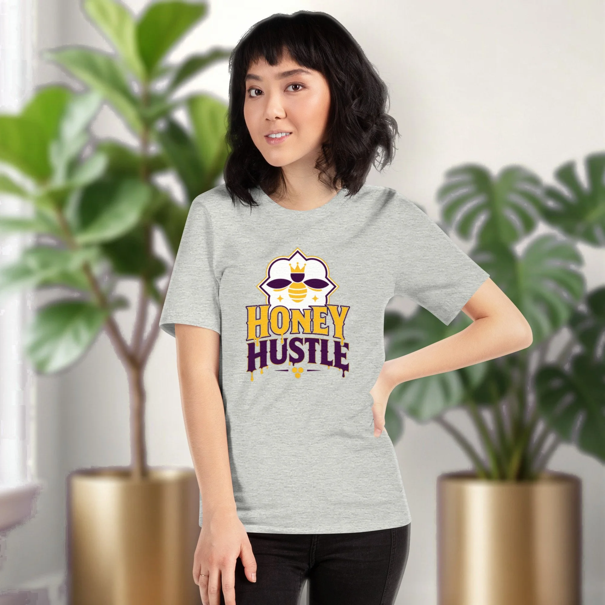 Honey Hustle tee in athletic heather, worn by a model in front of potted plants
