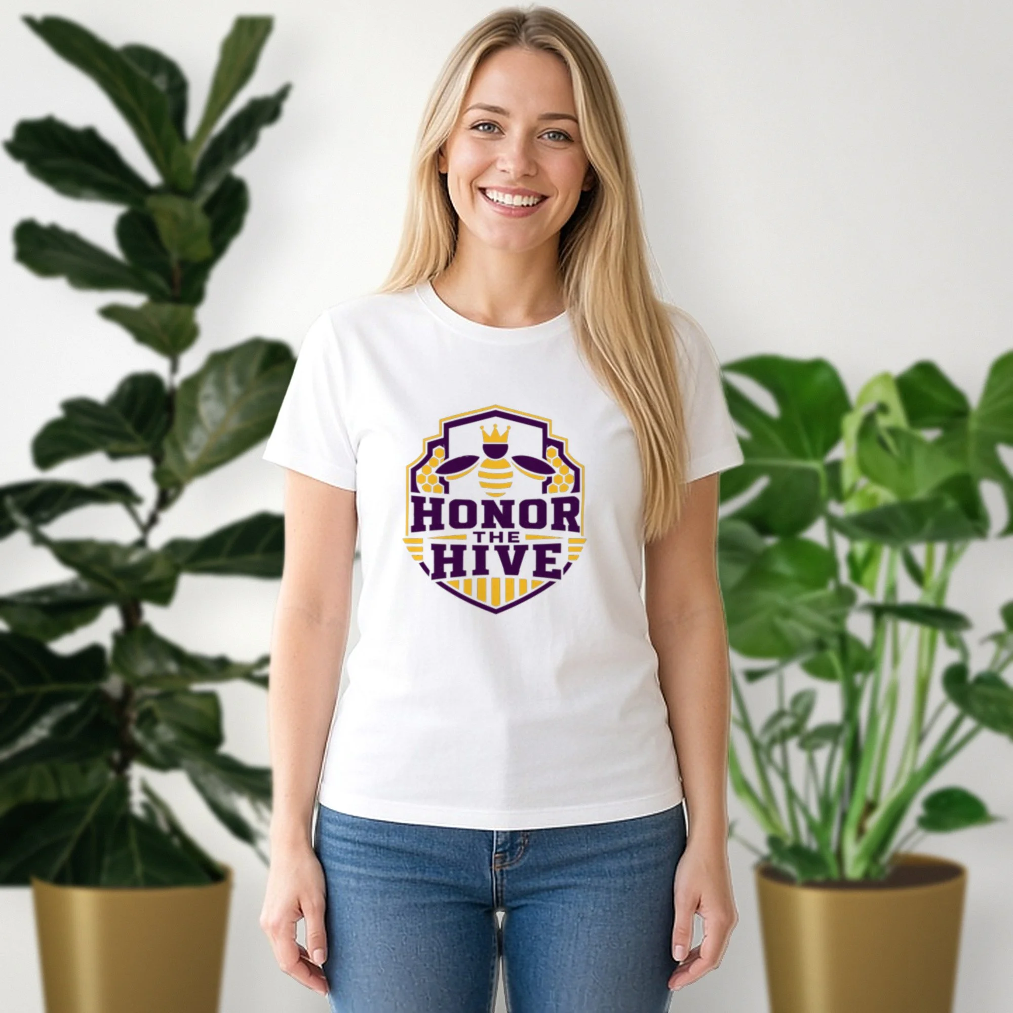 Honor the Hive tee in white, worn by a model in front of potted plants