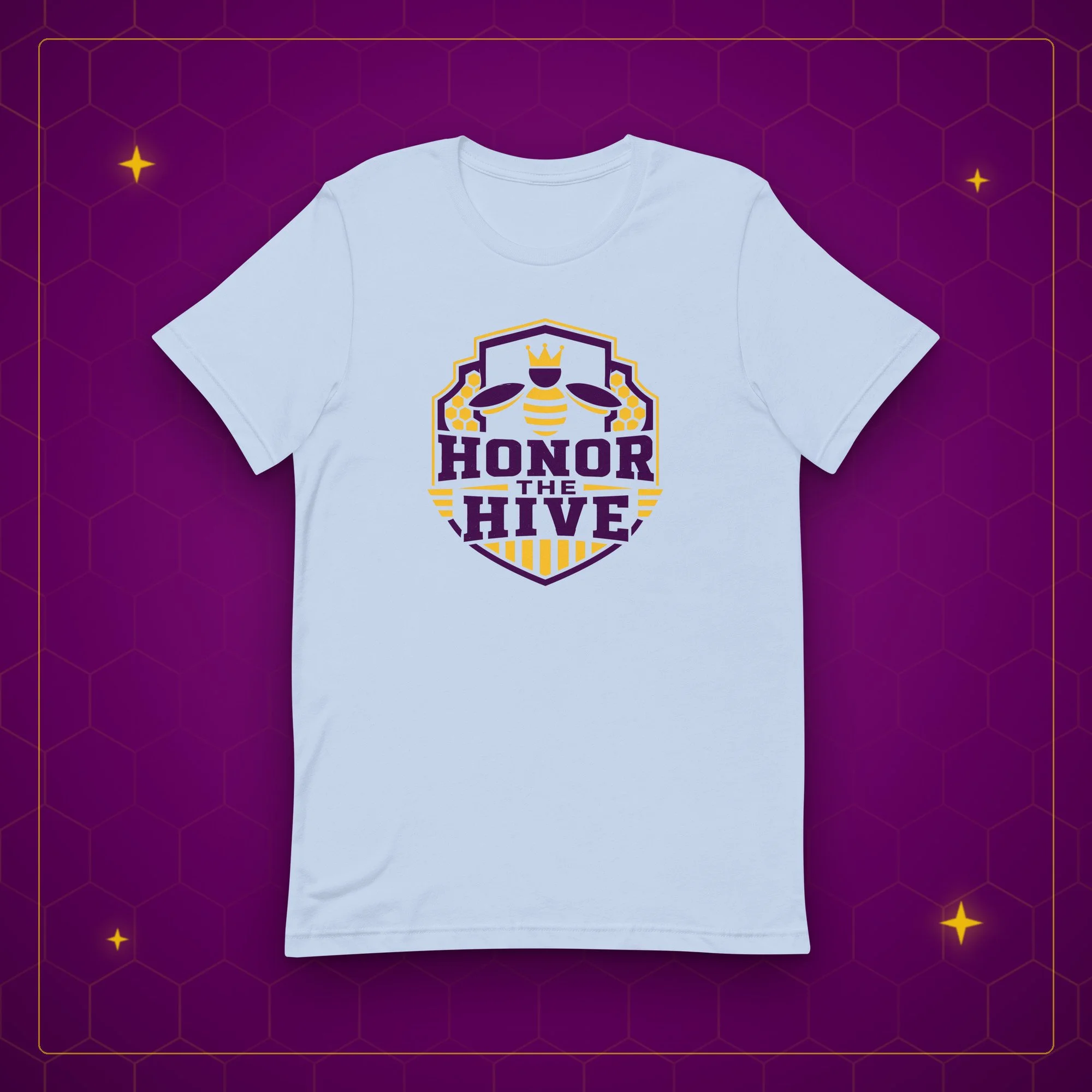 Honor the Hive tee in baby blue, laid flat on a purple background with gold sparkles