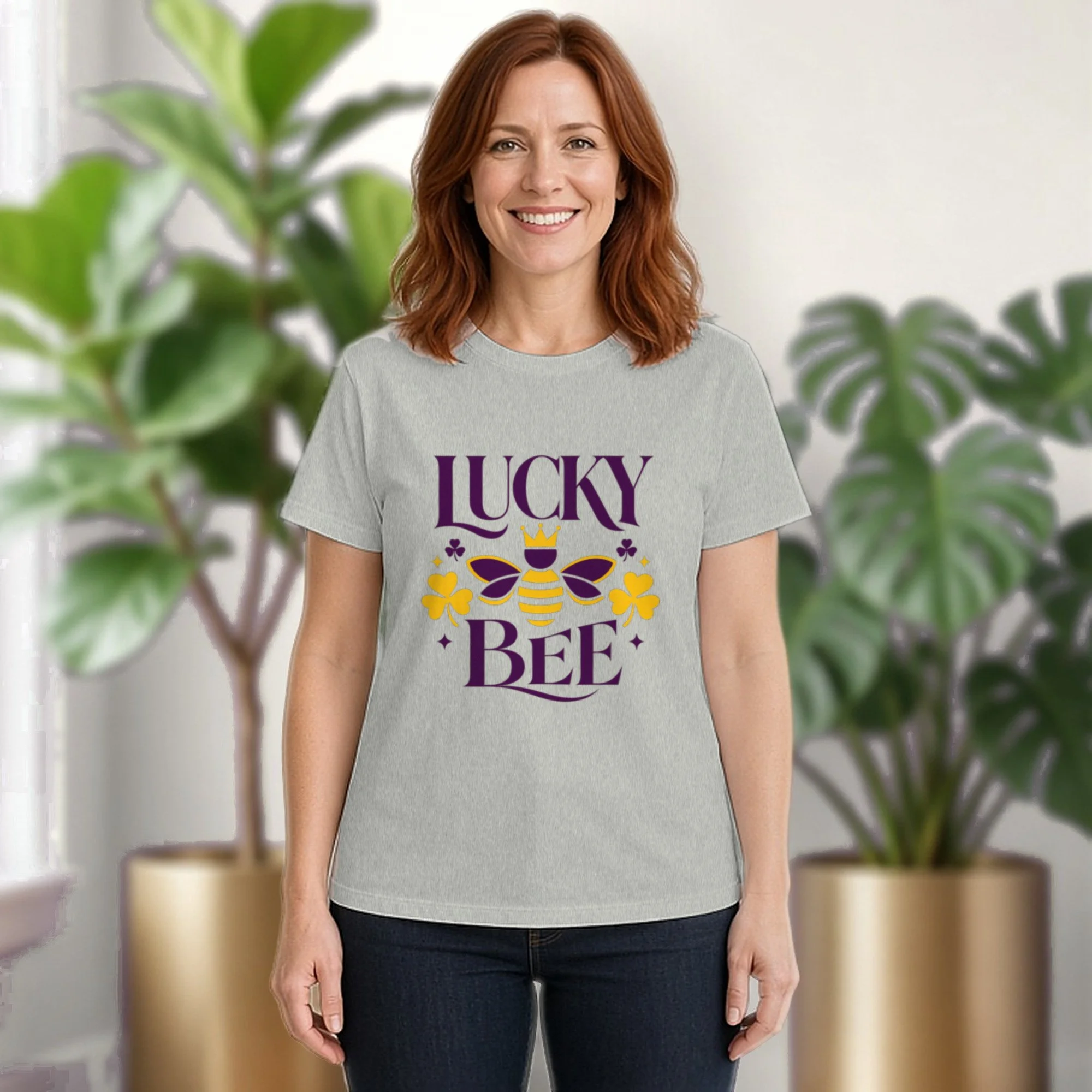 Lucky Bee tee in athletic heather, worn by a model in front of potted plants