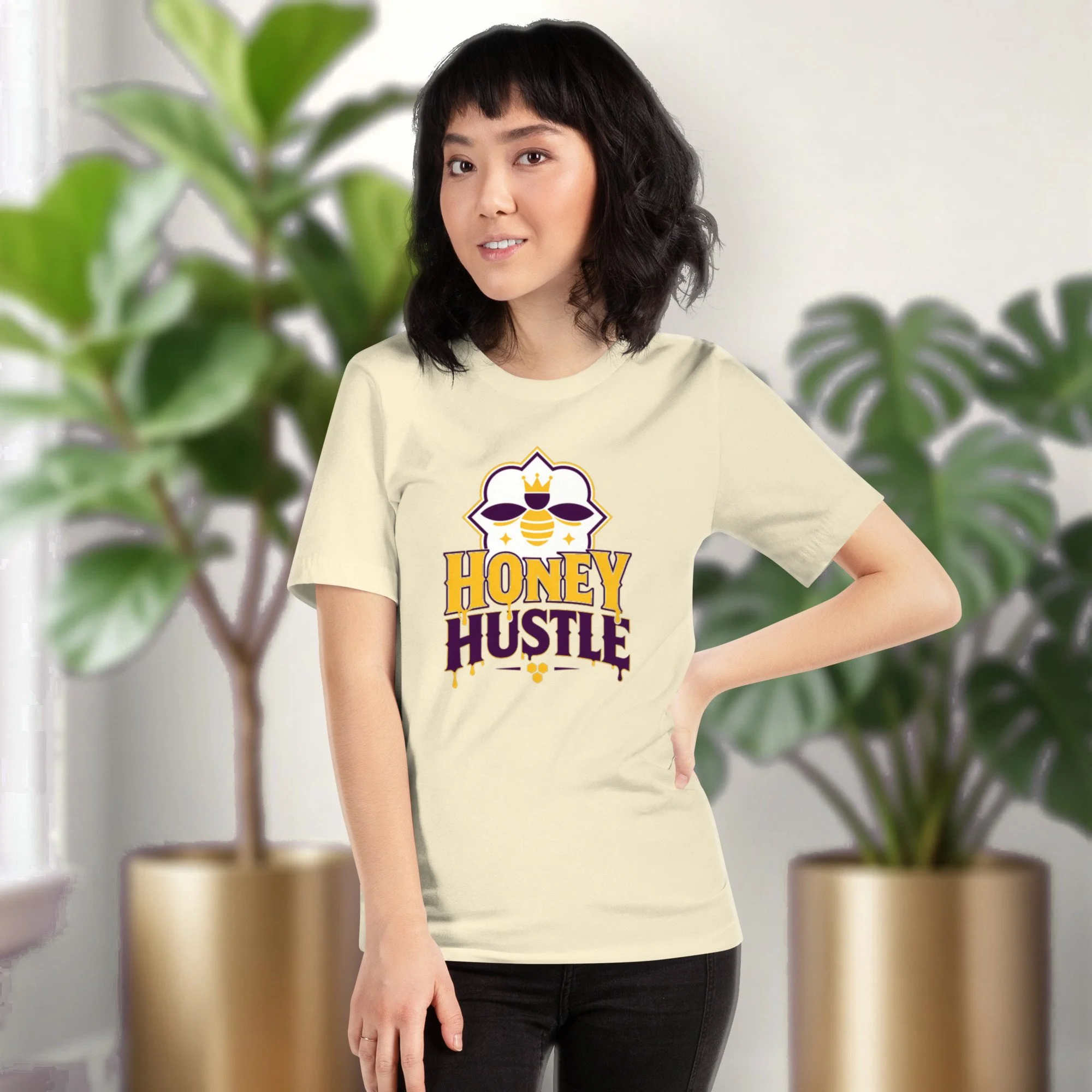 Honey Hustle tee in natural, worn by a model in front of potted plants