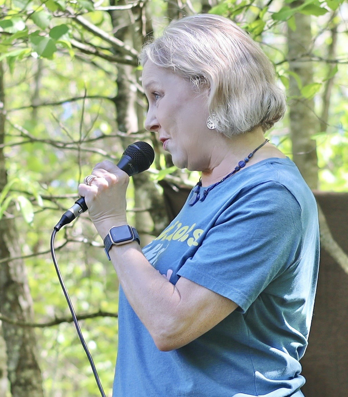 Woman speaking into a microphone outdoors