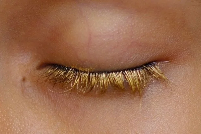 Close up image of eye with gold mascara