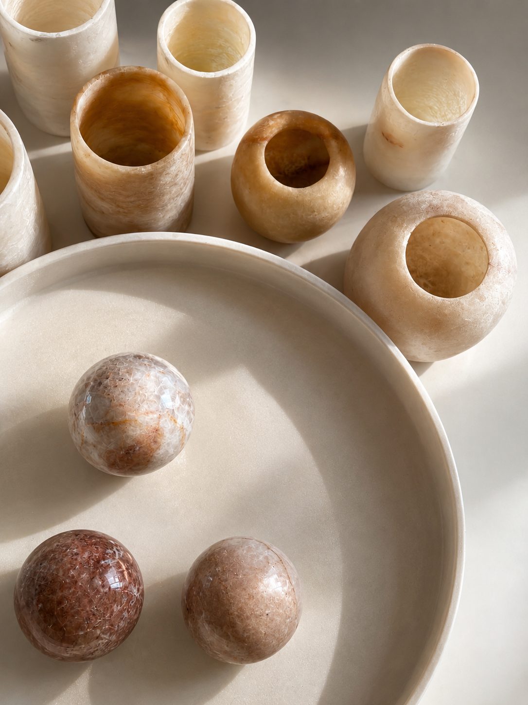 Stone vessels and rounded skincare tools arranged in soft light