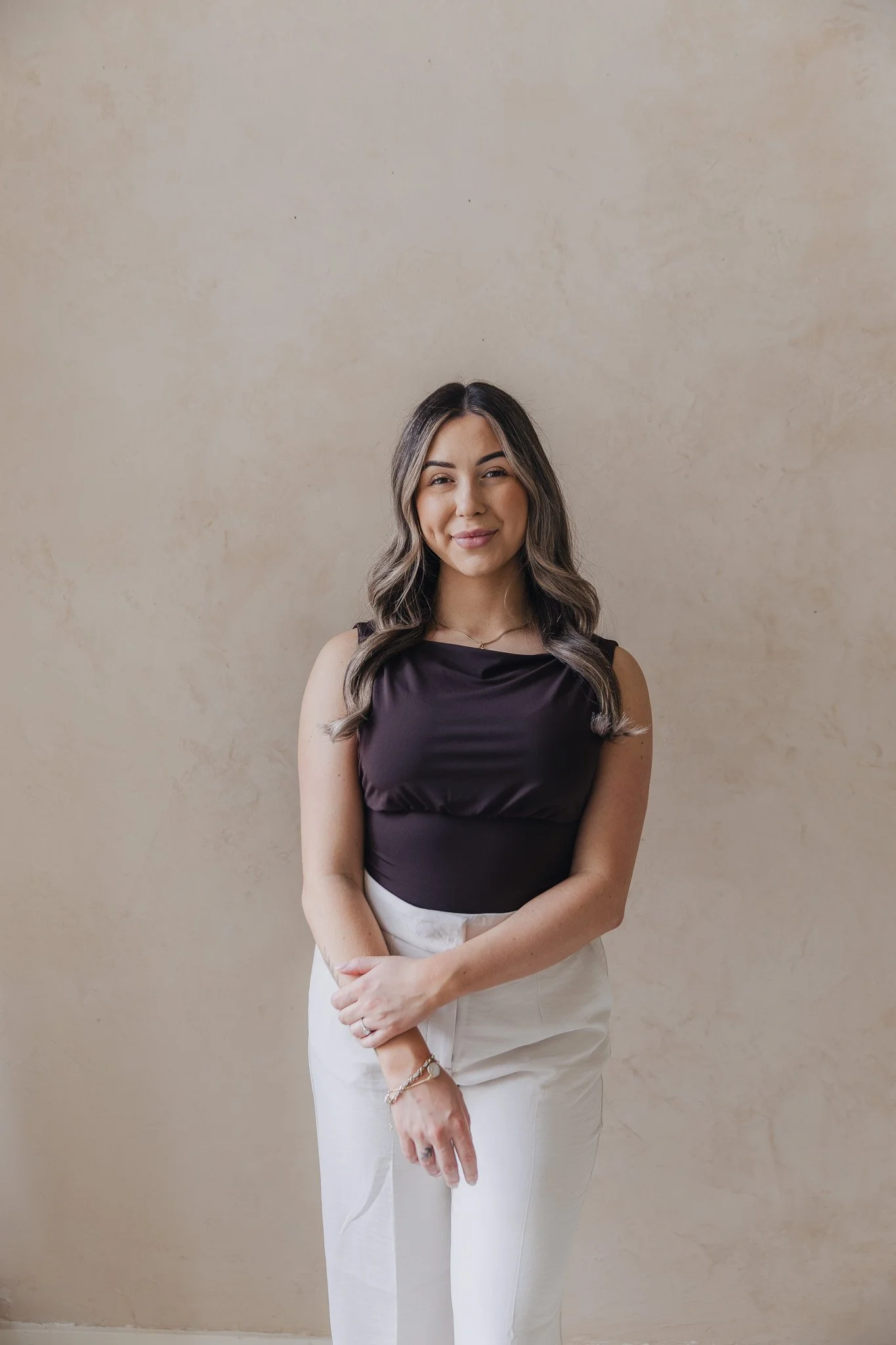 Jade Di Marzo, medical aesthetician at JRAD SKIN, photographed standing against a soft neutral backdrop