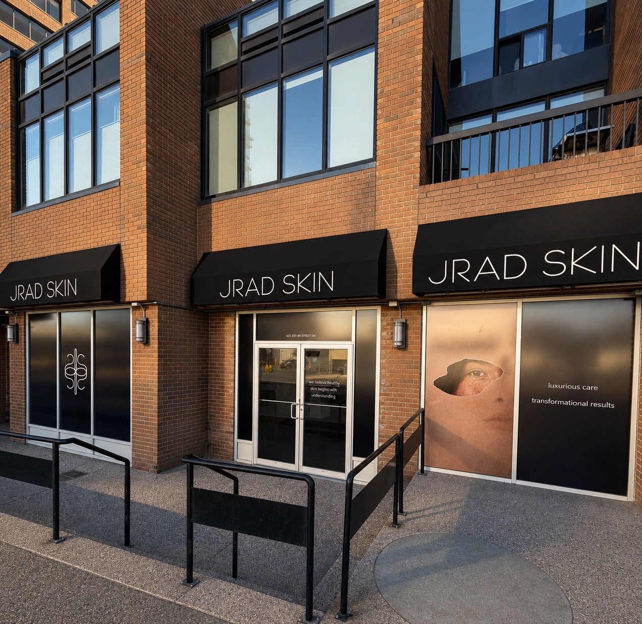 JRAD SKIN clinic exterior in Calgary showing the entrance, black signage and branded window graphics