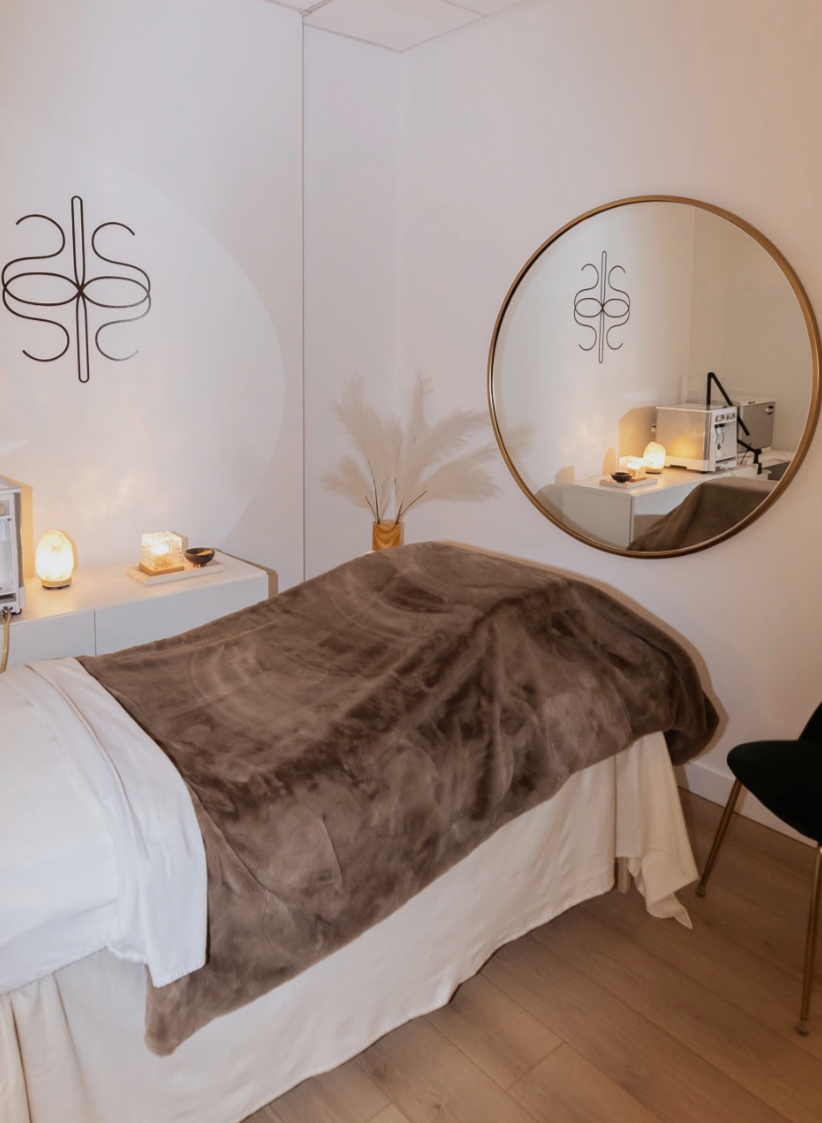 JRAD SKIN treatment room with a facial bed, mirror and soft lighting for in-clinic skin guidance check-in sessions.