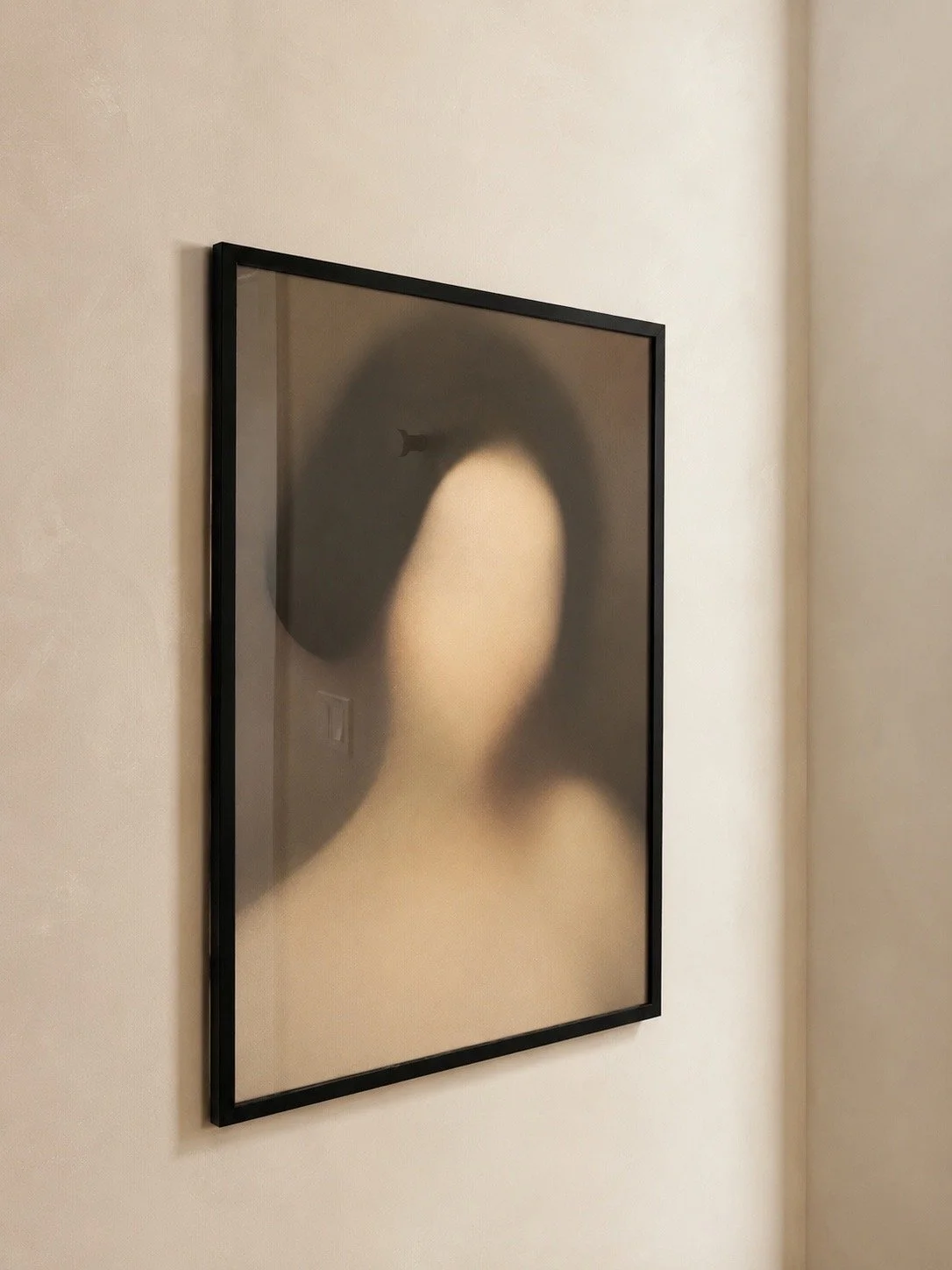 Framed artwork of an abstract woman in soft focus on a neutral wall inside the JRAD SKIN clinic