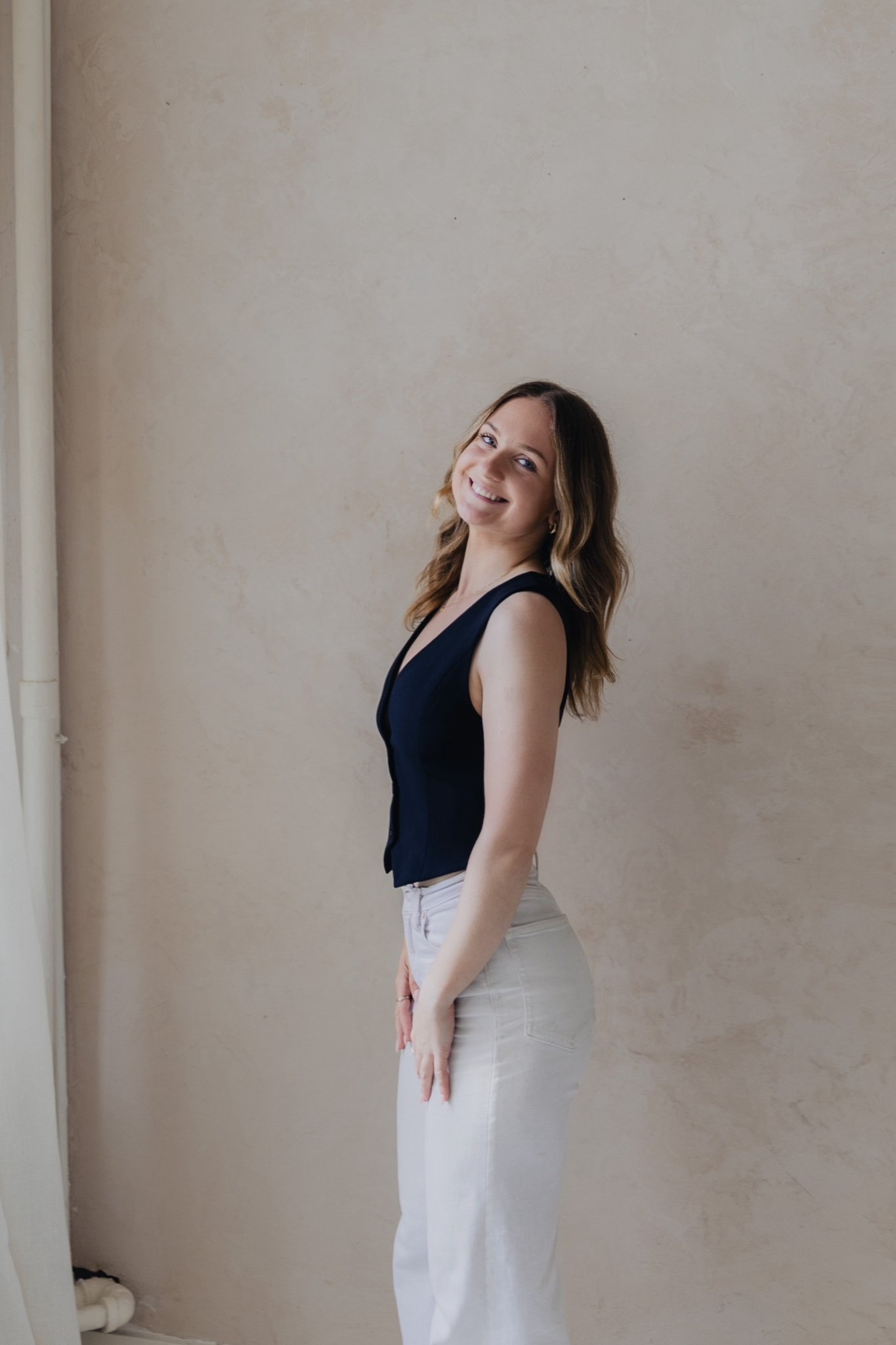 Ella Ostrikoff smiling in a portrait taken inside the clinic against a neutral wall