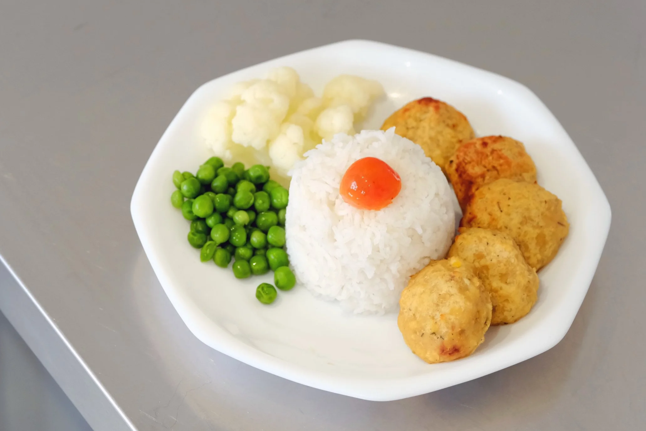 Children's food dish with rice and peas and vegetables