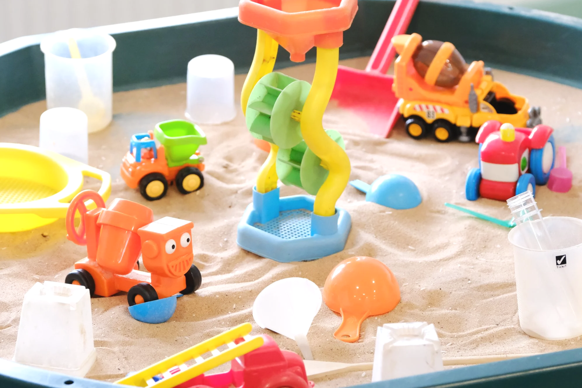 Sand pit with lots of colourful toys