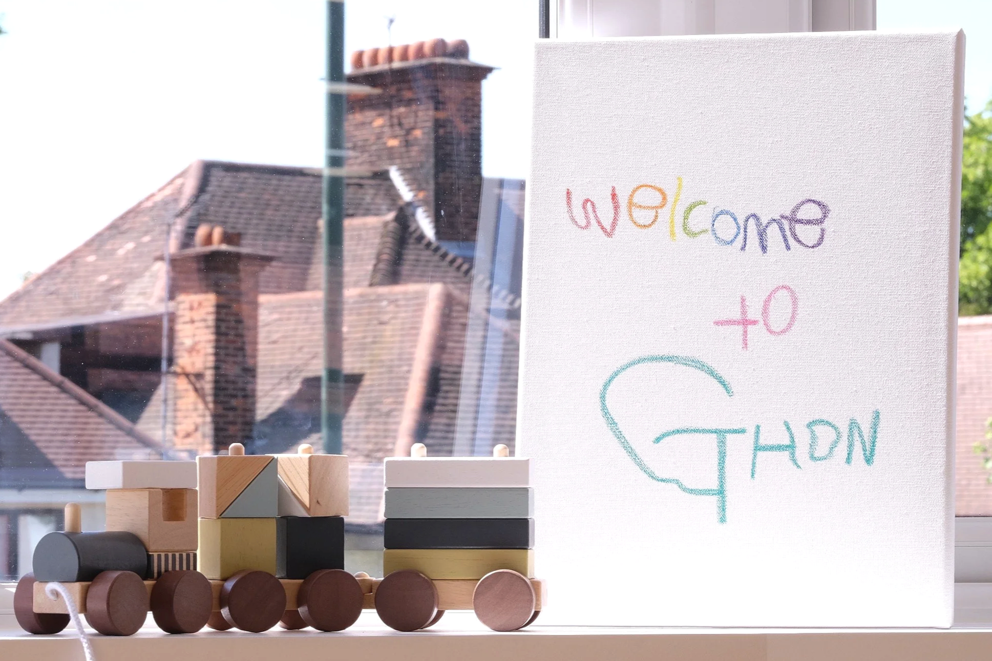Child handwriting of "Welcome to GHDN" written on a small white canvas