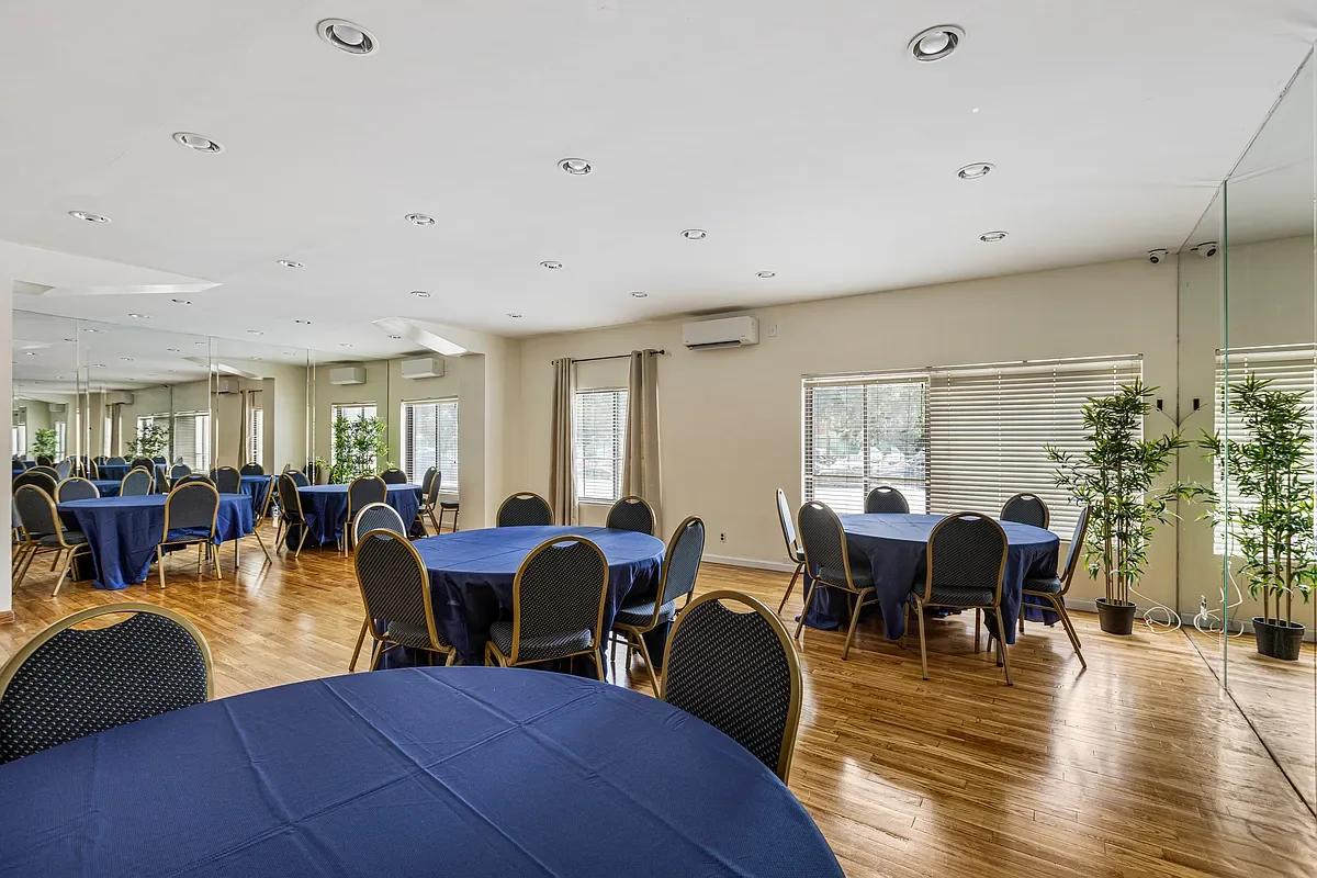 Tables with long tablecloths and plush chairs arranged in the Shore Towers community room.