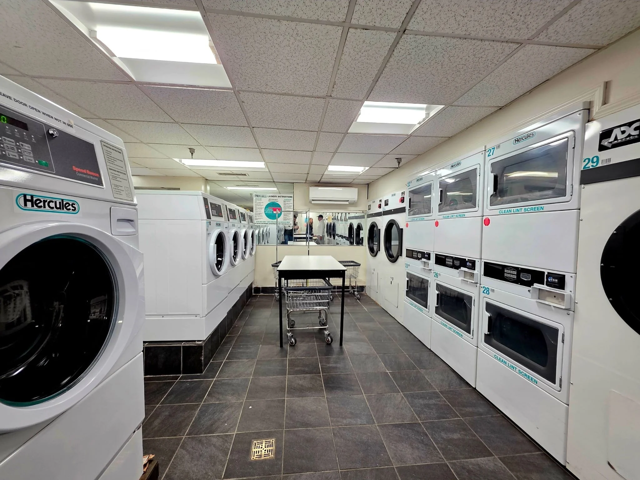 The laundry room at Shore Towers, showcasing multiple washing machines, dryers, and laundry carts.