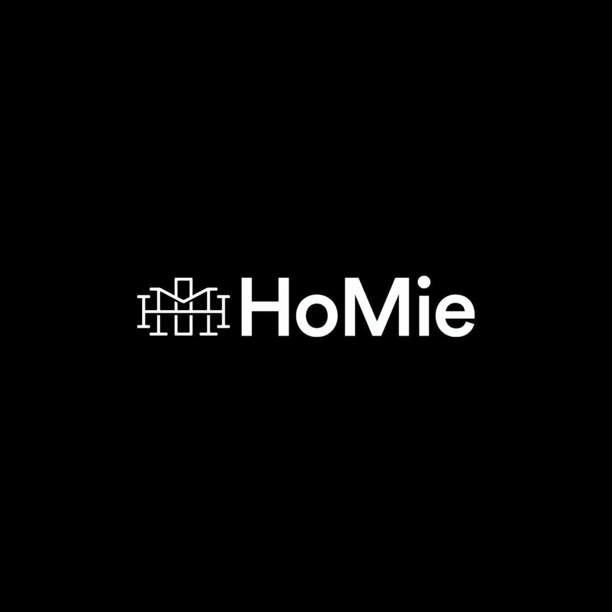 A logo with the word 'HoMie' in white text, featuring a simple line drawing of a house on the left side, all set against a black background.