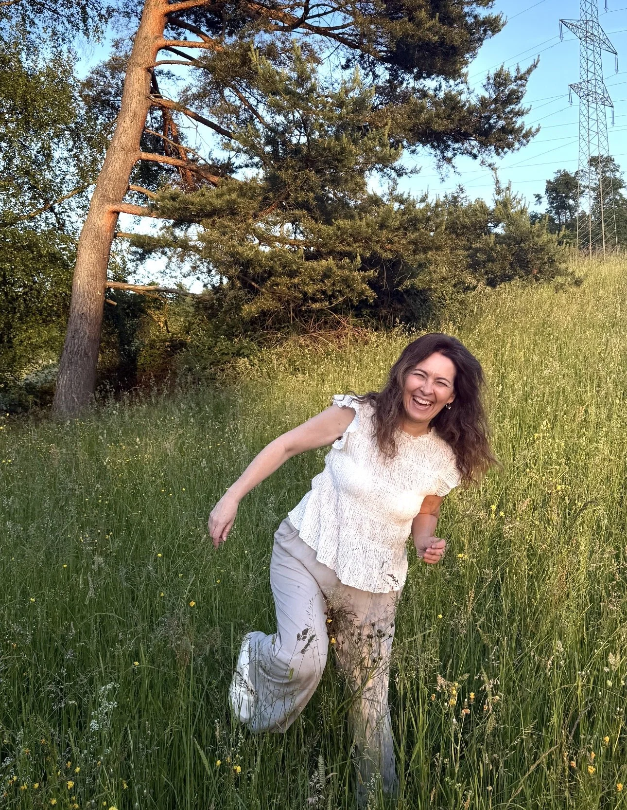 frau-springt-lacht-wildblumenwiese-sonnenuntergang-schweiz.jpg