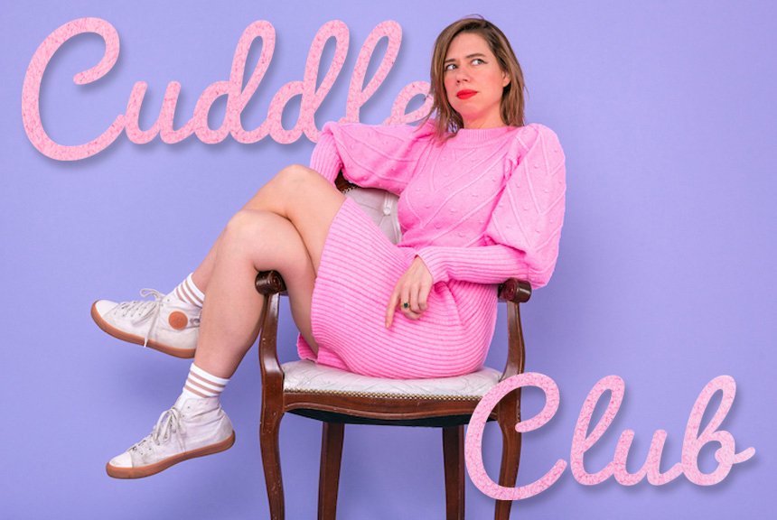 A woman sitting on a vintage chair against a purple background with pink text that says 'Cuddle Club'. She is wearing a pink sweater and skirt, white sneakers, and patterned socks, looking to the side with a thoughtful expression.