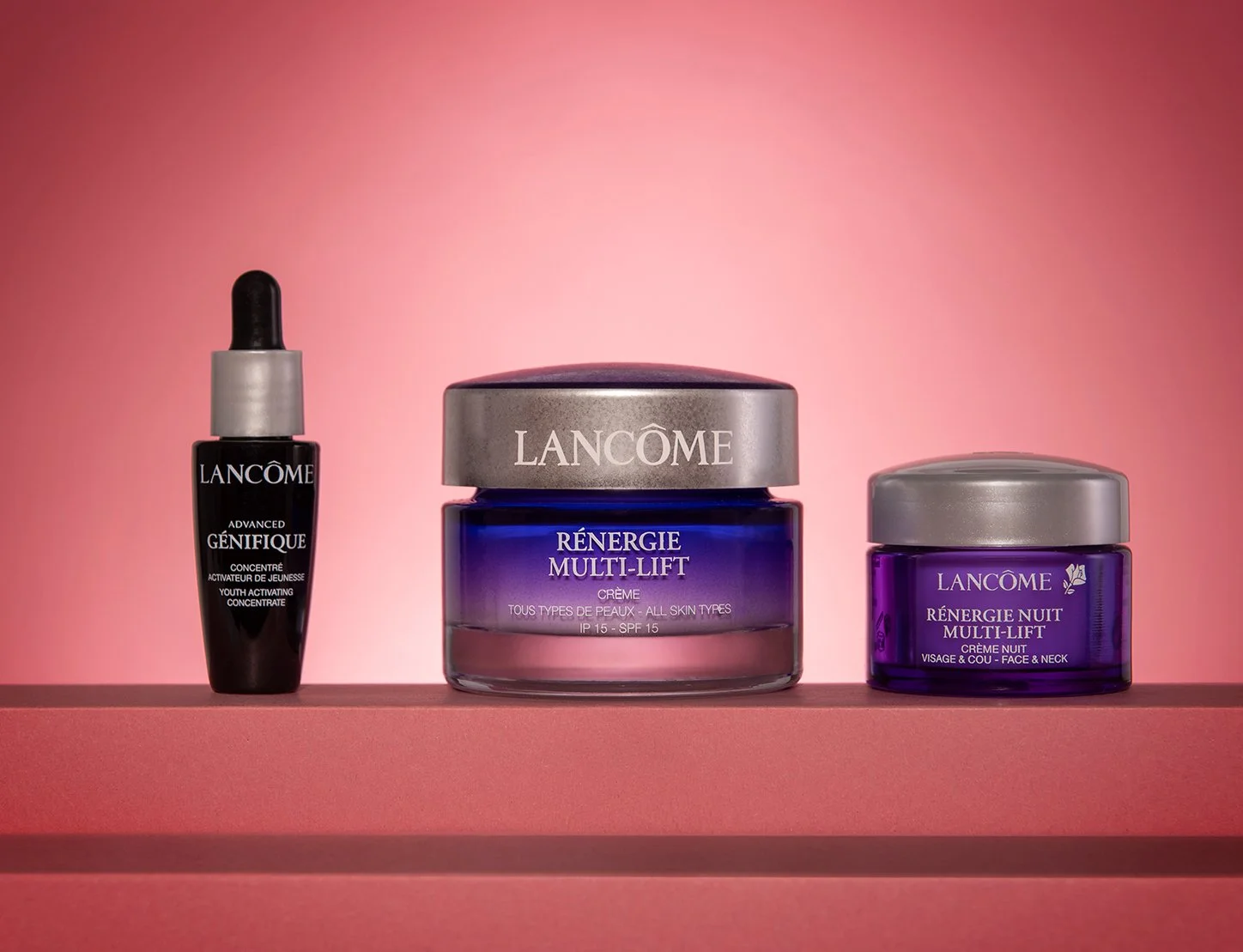 hero product photography shot showing a range of lancome cosmetics skincare and beauty products on a graduated pink background