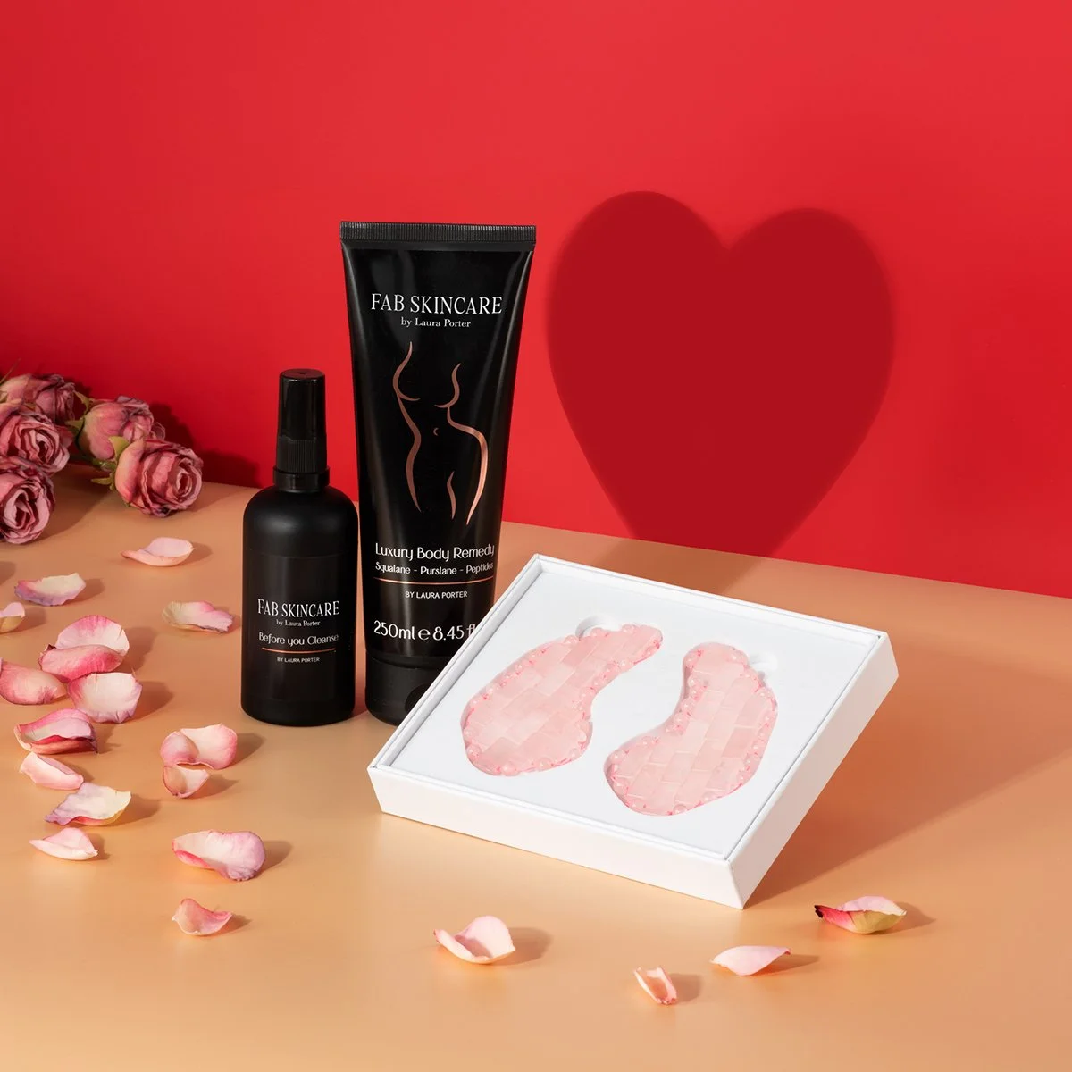 2 tubes of fab skincare by laura porter moisturiser cosmetics and eye patches with roses on a red background with heart hero photography by roy mccready 