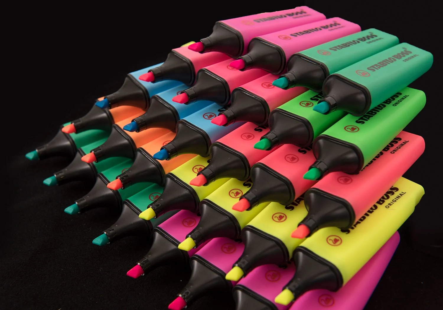 product photography shot showing a colourful spread of highlighter pens arranged on a black background