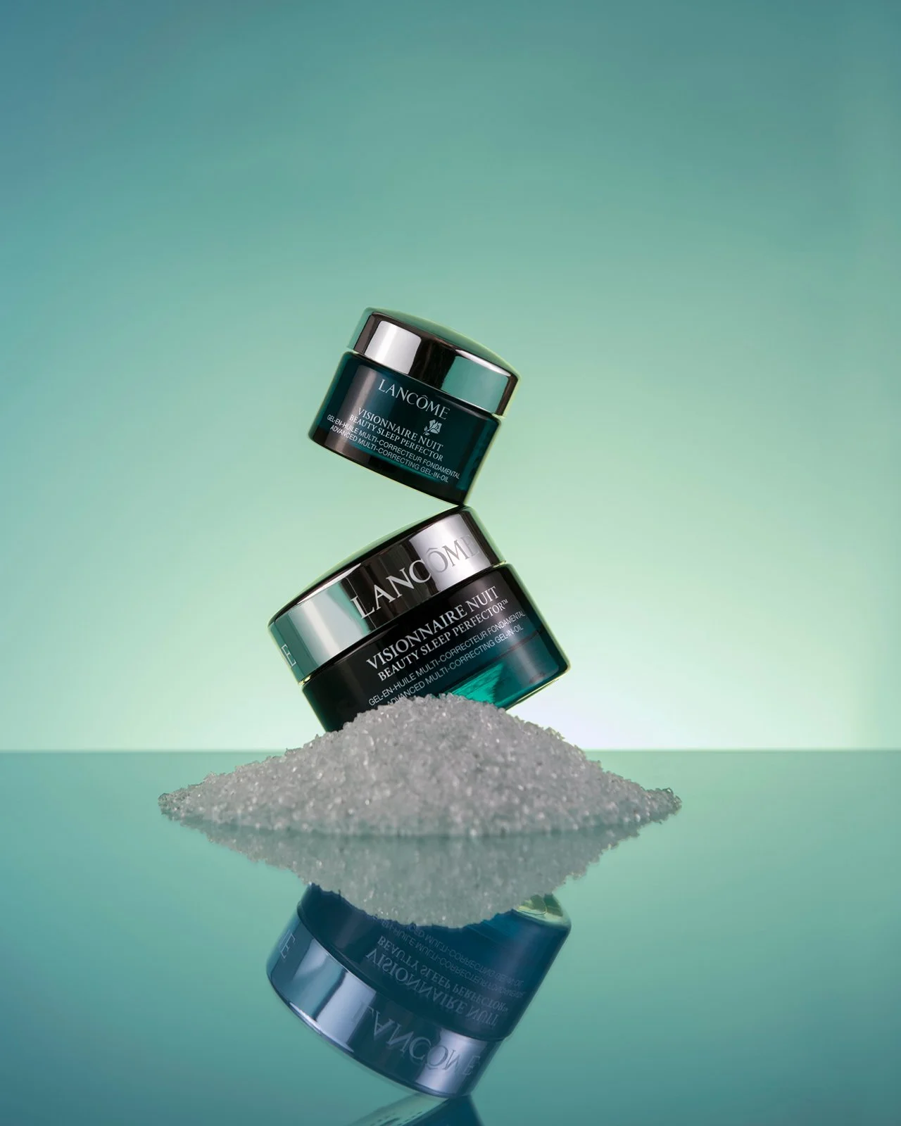 2 pots of lancome vissionnaire nuit cream balanced on a gradient green background commercial product photography by roy mccready
