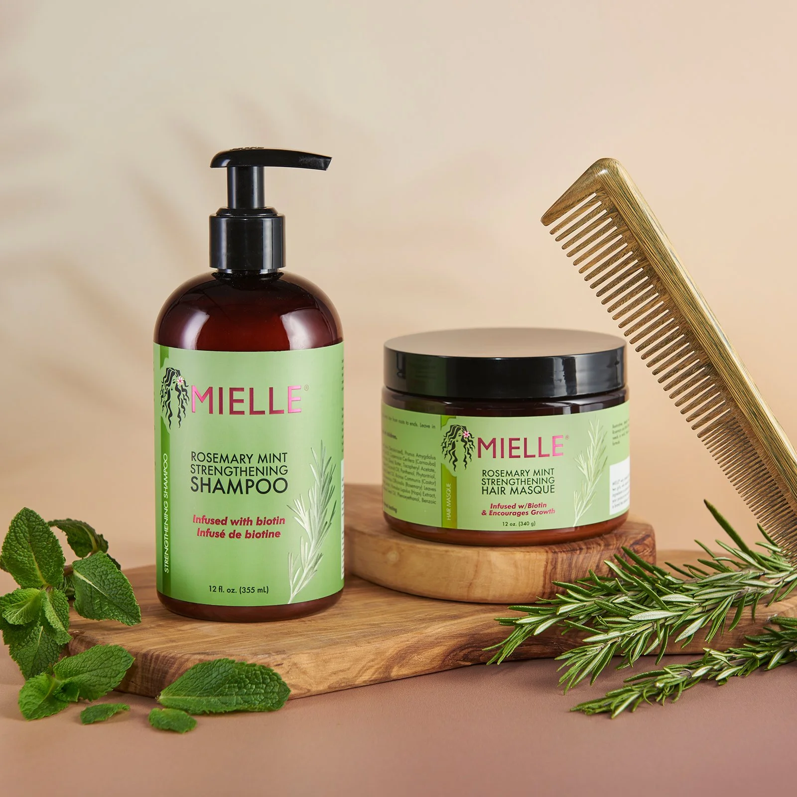hero product photography for mielle skincare and haircare products with herbs and comb on a wooden plinth with light brown background