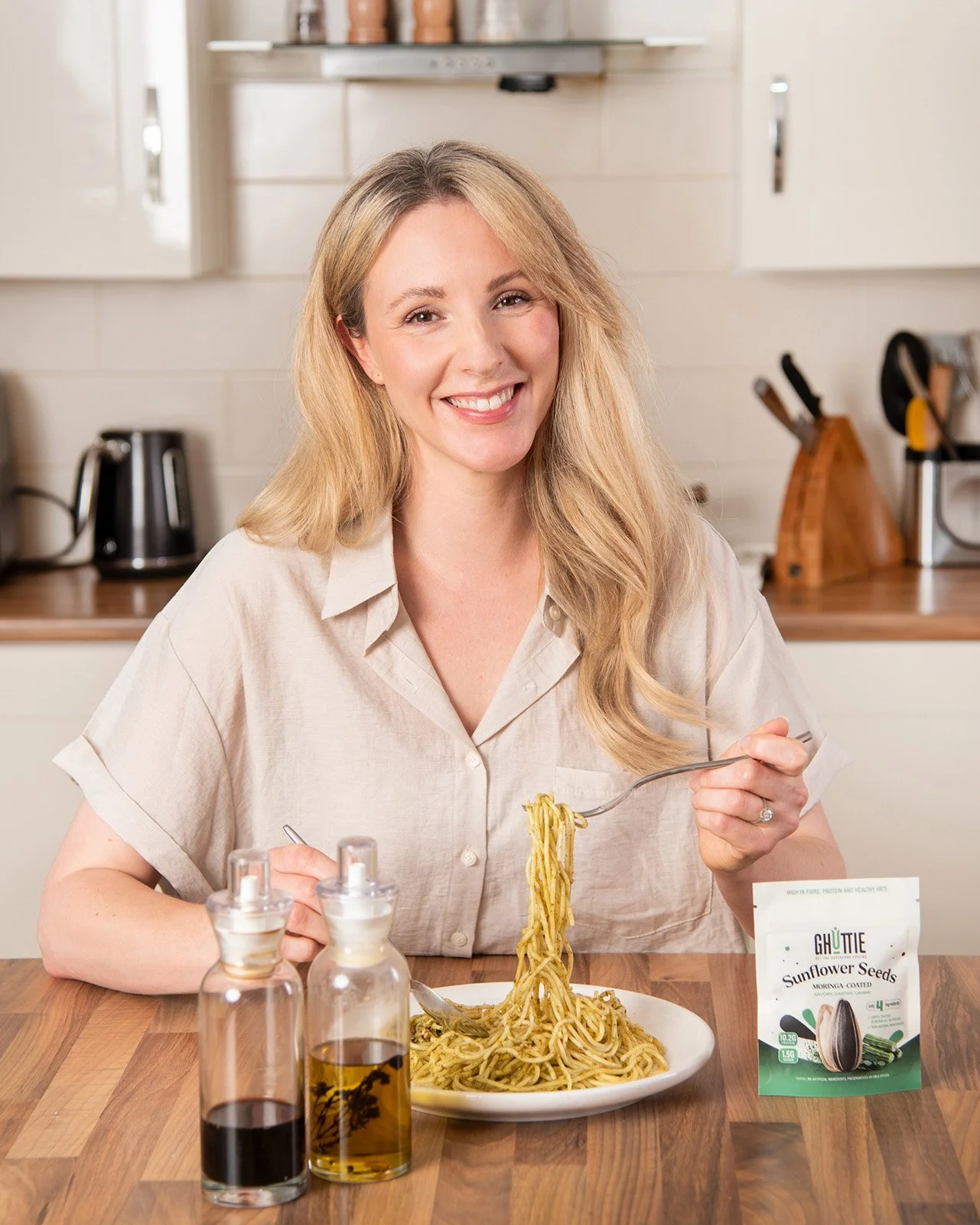 lifestyle photography showing a young athletic woman practicing yoga with a packet of gut health ghuttie sunflower snacks