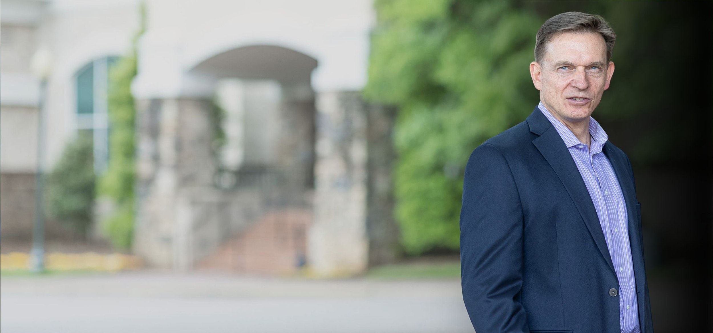 Steve Buisson PPC executive coach, standing in front of blurred resort background looking intentional and focused