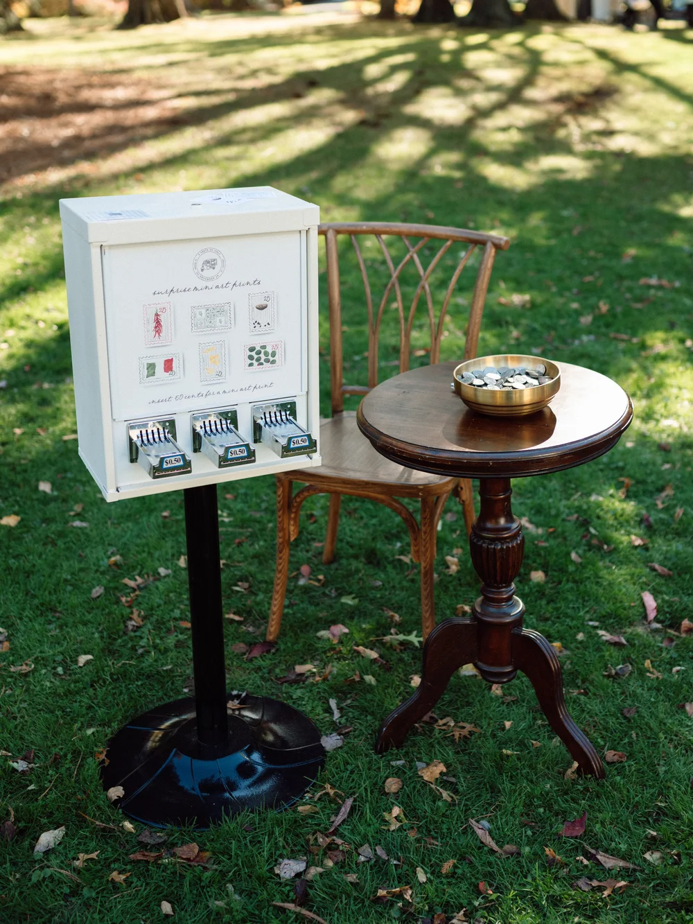 Mini print vending machine with tokens at an outdoor celebration