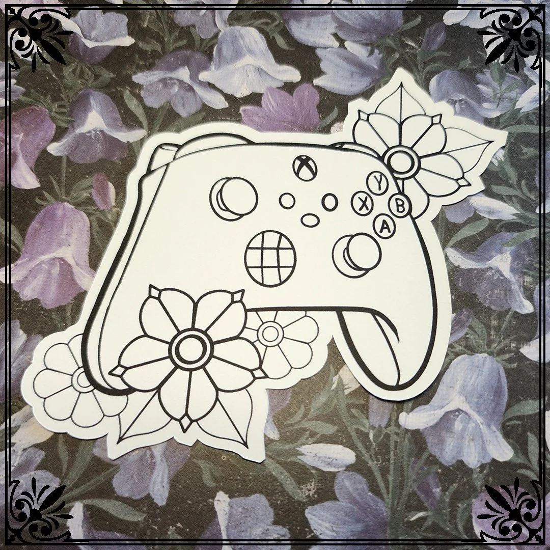 Line drawing of a video game controller decorated with flowers, placed on a purple flower-patterned background.