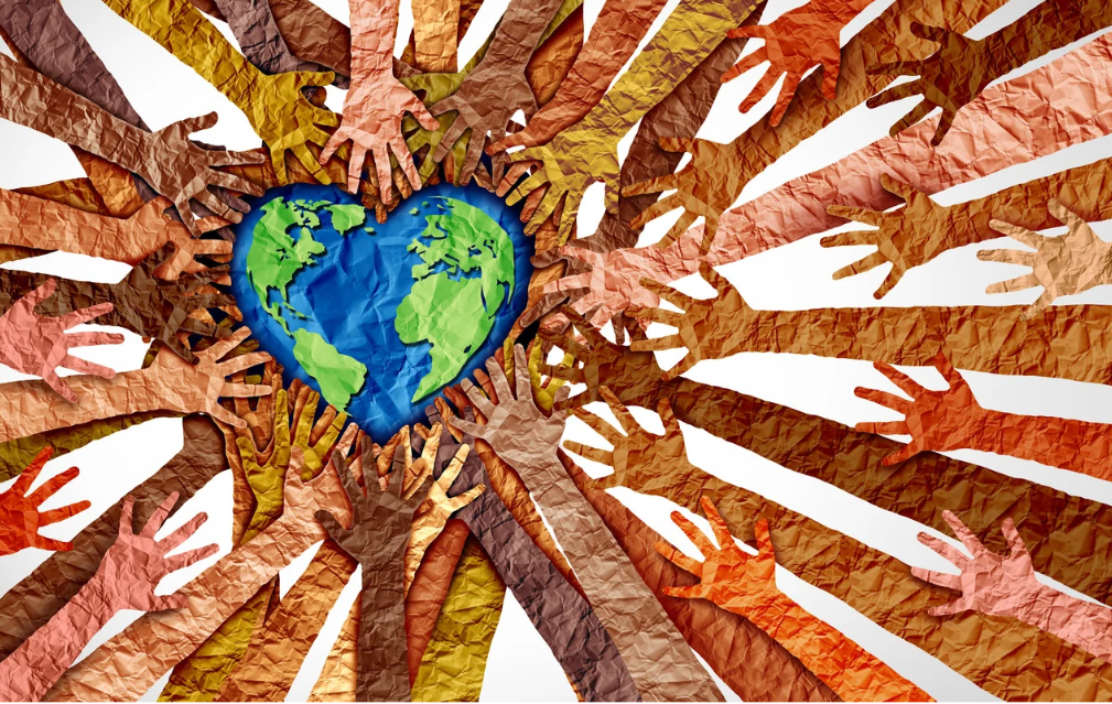 paper cut out of a heart-shaped earth that is blue for water and green for land, surrounded by numerous hands and arms extending around it to support and touch it.