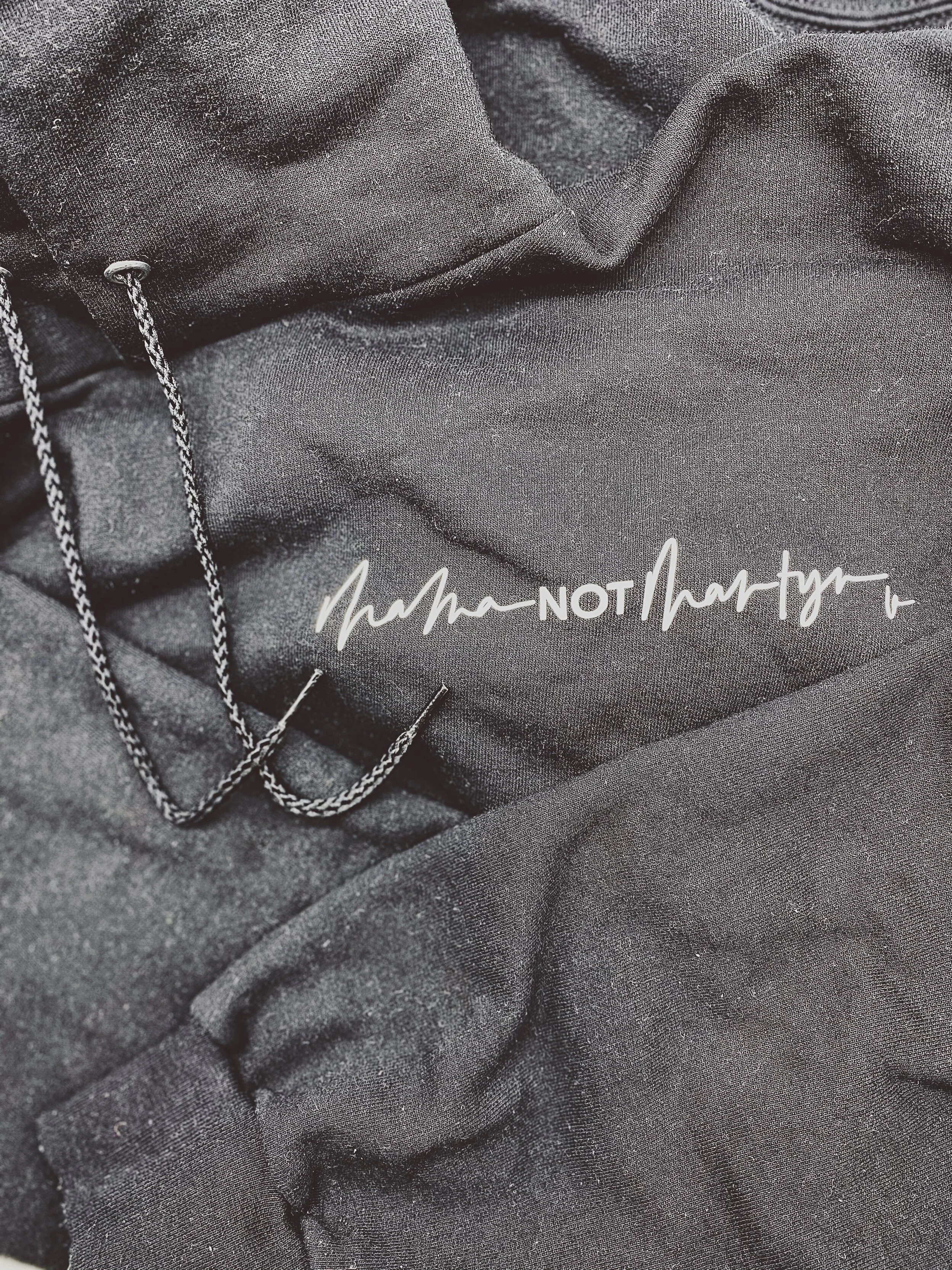 An image of the DBL Mama Not Martyr hoodie hand lettered and heat pressed in black and white. Sectioned under Wearable Art.