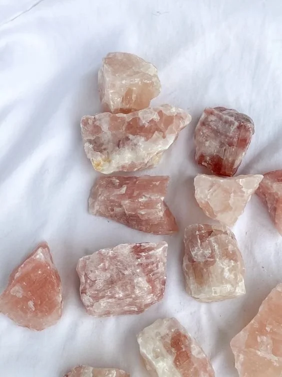 Several pink salt rocks on a white cloth.