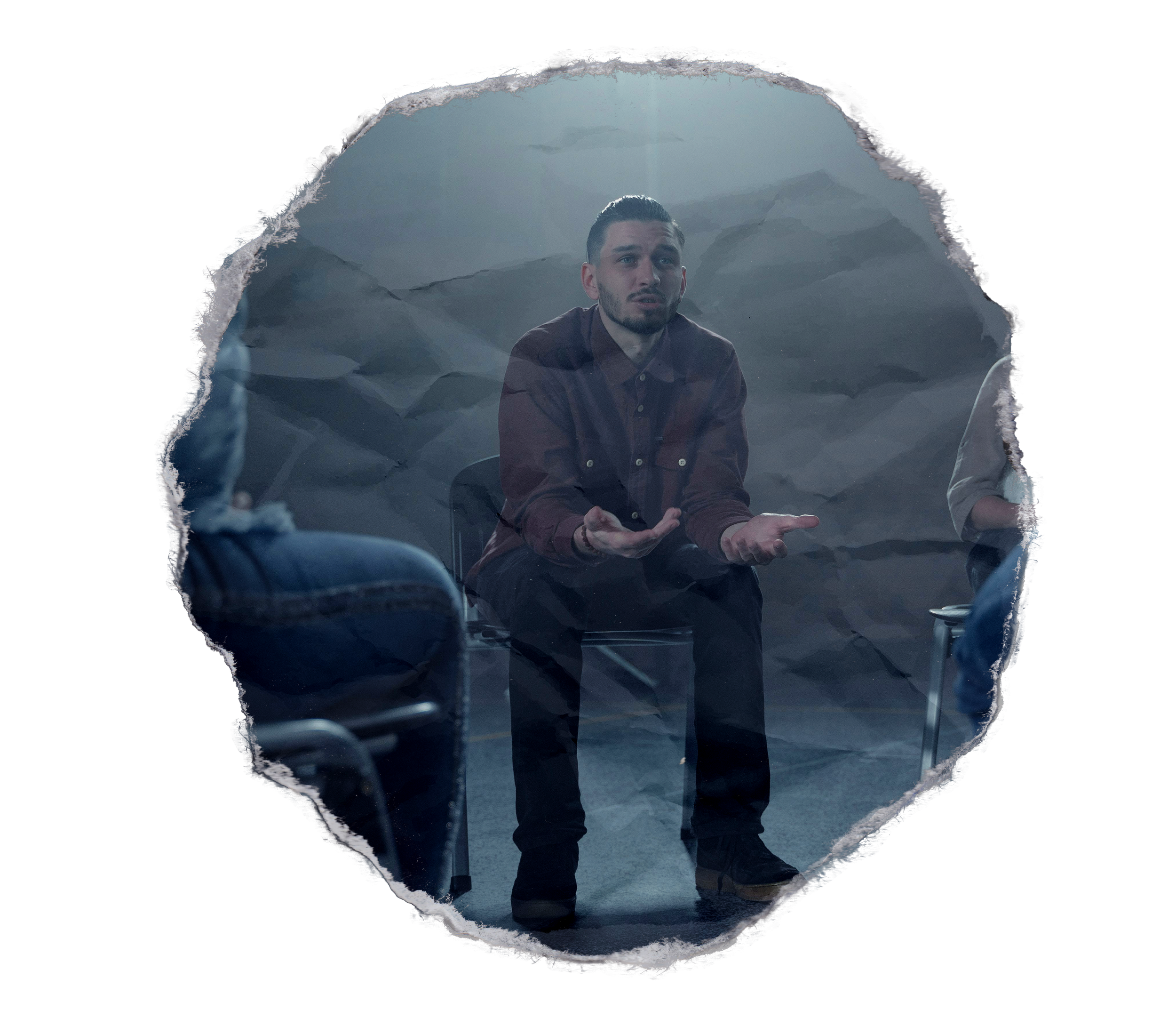 A man sitting in a chair surrounded by other people sitting in chairs during grief support group