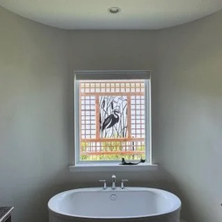 Custom cedar privacy trellis installed outside a master bathroom window, allowing natural light while screening the spa tub area.