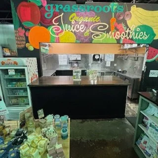 Custom coffee bar build at Grassroots Natural Food Store in Five Points, Jacksonville, Florida, positioned beneath a colorful organic juice and smoothie mural.