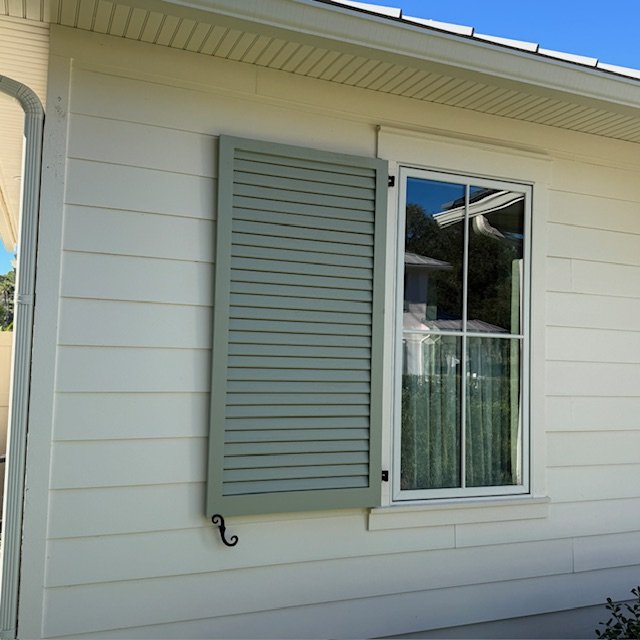 Custom louvered exterior shutters installed on a riverfront home in Palm Valley, Ponte Vedra Beach, Florida, designed for coastal durability and shade control.