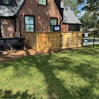 Custom cedar AC and pool equipment privacy enclosure installed at an Avondale home in Jacksonville, Florida, designed to blend with traditional brick architecture.