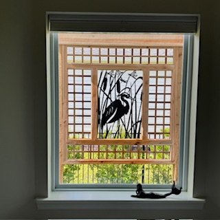 Custom cedar privacy trellis installed outside a master bathroom window, allowing natural light while screening the spa tub area.