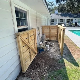 Cedar pool equipment enclosure with hinged access doors at a residential property in Ortega, Jacksonville, Florida, providing ventilation and easy maintenance access.