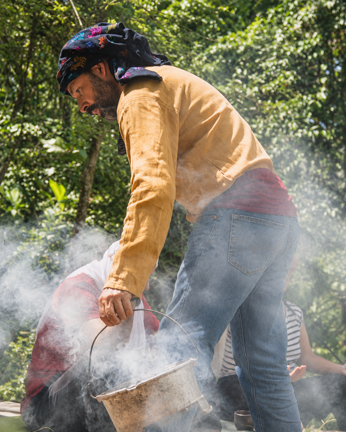 Andrés tending the smoke of a copal offering in the forest.