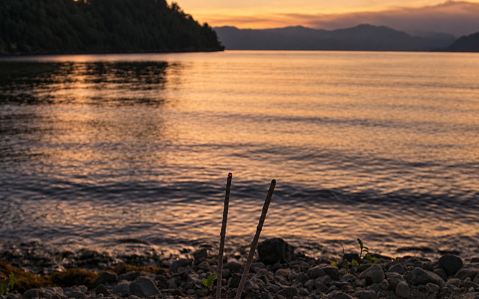 Incense burning beside Lake Atitlán at dusk